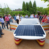 A crowd takes a close look at Penumbra, Team PrISUm's latest solar vehicle