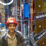 Jim Cochran stands in front of the ATLAS Detector in Europe.