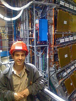 Jim Cochran stands in front of the ATLAS Detector in Europe.