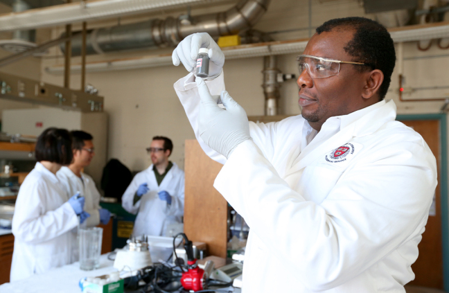 Martin Thuo in his lab with a vial containing liquid-metal particles