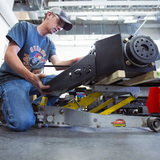 Clayton Hamilton works on a tractor component in a workshop