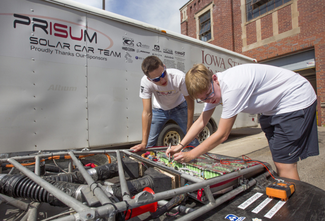 Team PrISUm members check their solar car's battery pack.