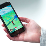 Hand holding phone displaying Pokemon GO game