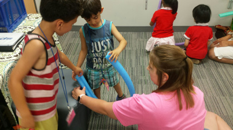 Students testing idea for a roller coaster made from a pool noodle