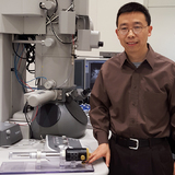 Xiaoli Tan with special specimen holder and a tramsmission electron microscope.