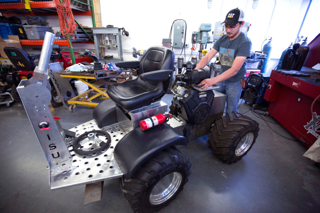 James McCormick works on a quarter-scale tractor in a workshop