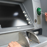 Person inserting debit card in ATM