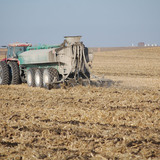 Tractor and farm equipment applying manure to a farm field