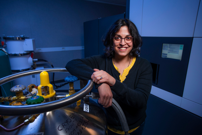Dipa Sashital leans against scientific equipment in a laboratory in the ISU Molecular Biology building