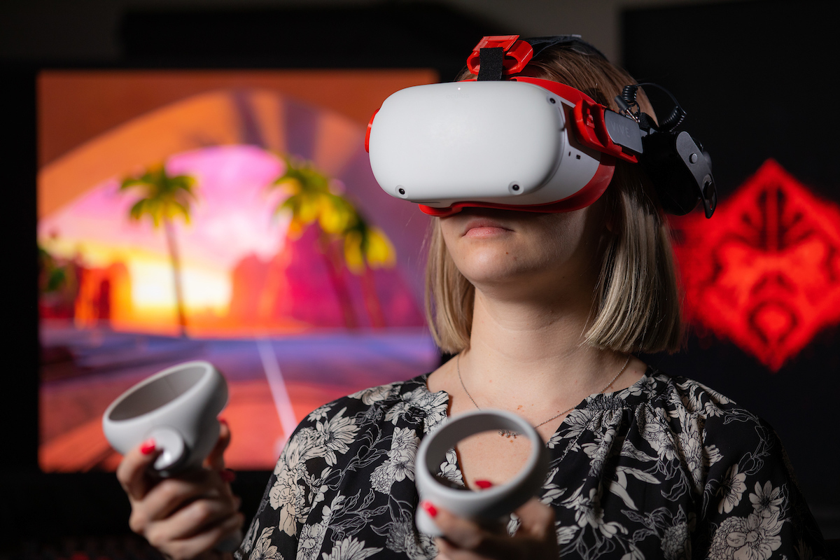 Taylor Doty, a Ph.D. student in psychology and human computer interaction, wears a VR headset at Iowa State, 2022.