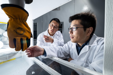 Guowen Song and Rui Li looking at safety glove in lab