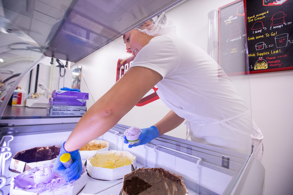 ISU Creamery employee Emily Tapken scoops some ice cream inside the creamery store in the Food Sciences Building. Photo by Christopher Gannon/Iowa State University.