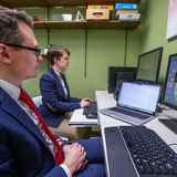 Associate professor Evgeny Chukharev, left, and Wren Bouwman, Ph.D. student in Applied Linguistics and Technology, use an eye tracking system as part of their development of an intelligent tutoring system inside Ross Hall. Photo by Christopher Gannon/Iowa 