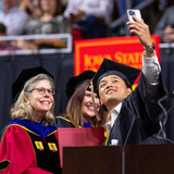 Student takes a selfie with President Wintersteen at commencement spring 2023