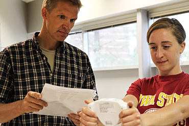ISU researcher Gregory Welk (left) and graduate student Katie Paulson study a BMI/body fat scale.