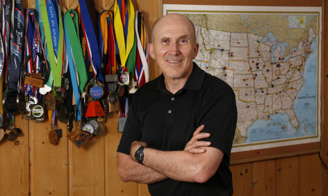 Dave Swenson with several of his medals and map of race locations