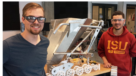 Tyler Broich and Phillip Molnar pose with the space mining robot as it is being built.