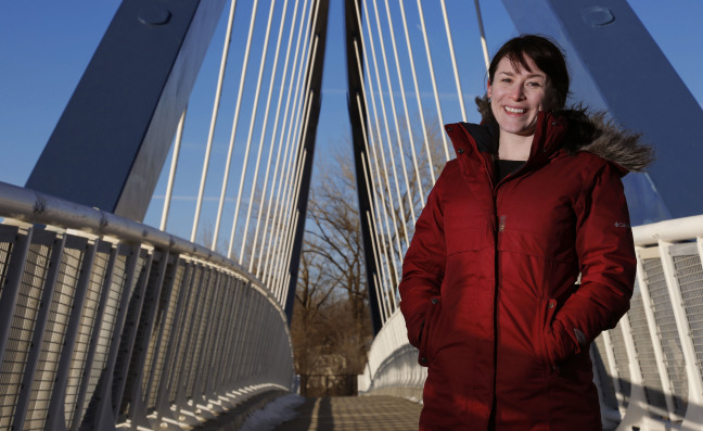 Katy Swalwell standing on I-235 pedestrian bridge in Des Moines