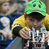 A student lines up his team's robot during FIRST LEGO League competition.