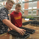 Ames High students Jake Schmit and Scott Junck work on a greenhouse experiment.