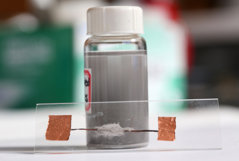 A vial of liquid-metal particles and an example of heat-free soldering