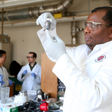 Martin Thuo in his lab with a vial containing liquid-metal particles 