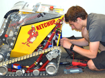 An Iowa State student repairs a mining robot.