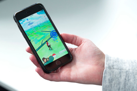 Hand holding phone displaying Pokemon GO game