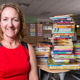 Emily Hayden in a classroom with stacks of books