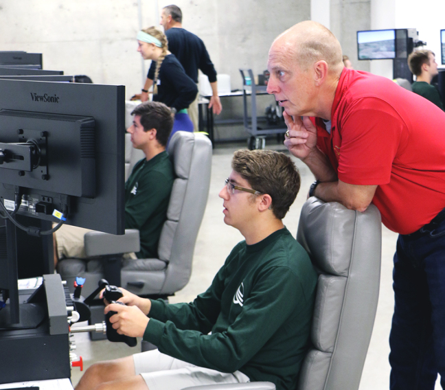 Retired astronaut Clayton Anderson works with a student during this year's Spaceflight Operations Workshop.