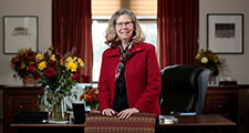 Wendy Wintersteen standing behind chair in office