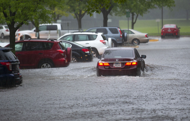 Car driving through a flooded parking lot