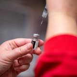 Nurse using a syringe to draw a dose of COVID-19 vaccine