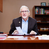 John Lawrence sitting at desk in his office