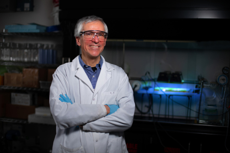 Jacek Koziel stands in front of ultraviolet equipment in a laboratory.