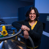 Dipa Sashital leans against scientific equipment in a laboratory in the ISU Molecular Biology building