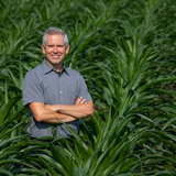 Matthew Hufford stands by himself in a corn field