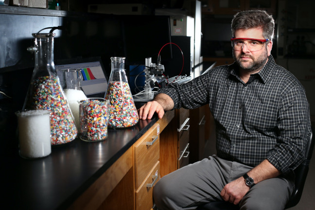 Keith Vorst in an Iowa State laboratory with pieces of recycled plastics on a lab table