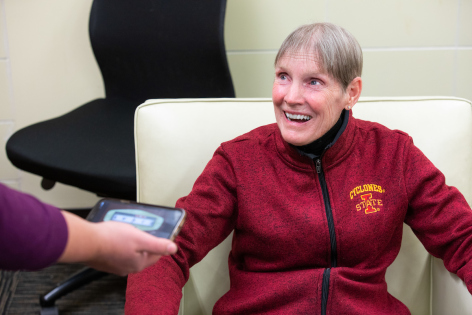 Associate Professor of Kinesiology Elizabeth Stegemoller measures Kathy Gundlach's range of pitch with an app on her phone.
