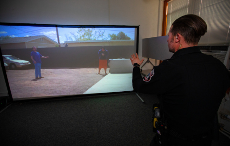ISU Police Officer Derek Doebel stands in front of the VirTra-100 screen in East Hall on the ISU Campus, Feb. 2022.
