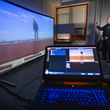 ISU Police Chief Michael Newton talks to the projected image on the VirTra-100 training simulator.