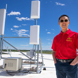 Hongwei Zhang, on the roof of the Economic Development Core Facility with hardware for rural wireless technology.