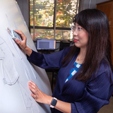 Assistant Professor Ling Zhang uses a garment pattern digitizer to design her prototypes. 