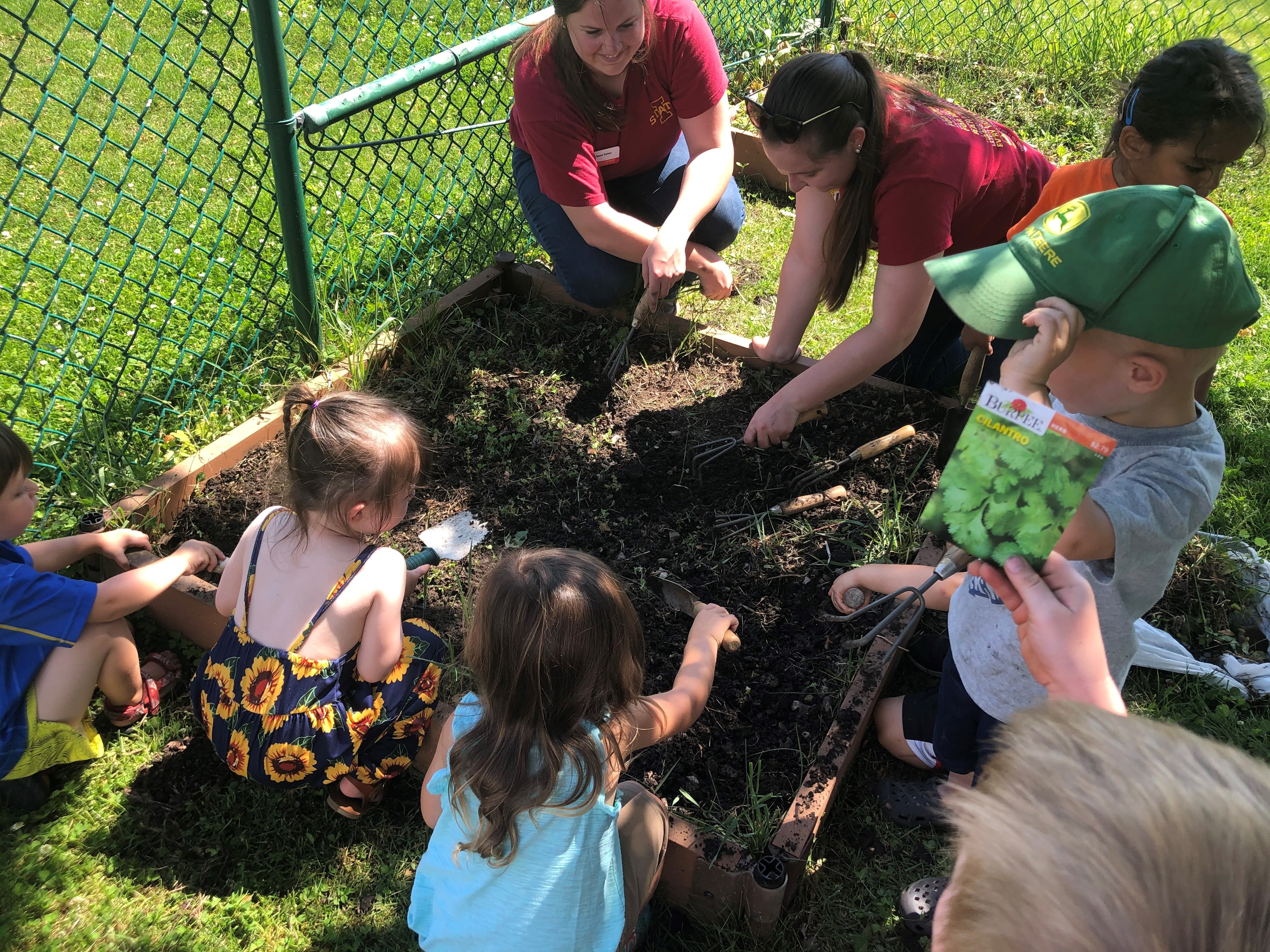 Rising Star interns working with children to plant garden