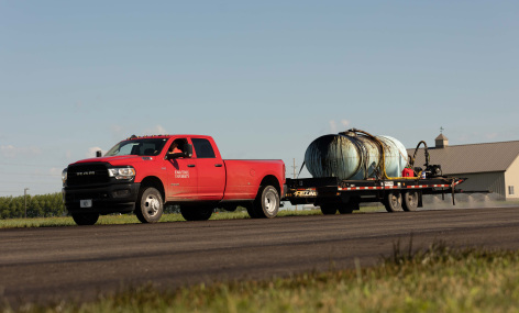 Red Iowa State truck applying soybean-based technology to paving project