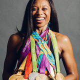 Allyson Felix smiles while numerous track medals hang from her neck