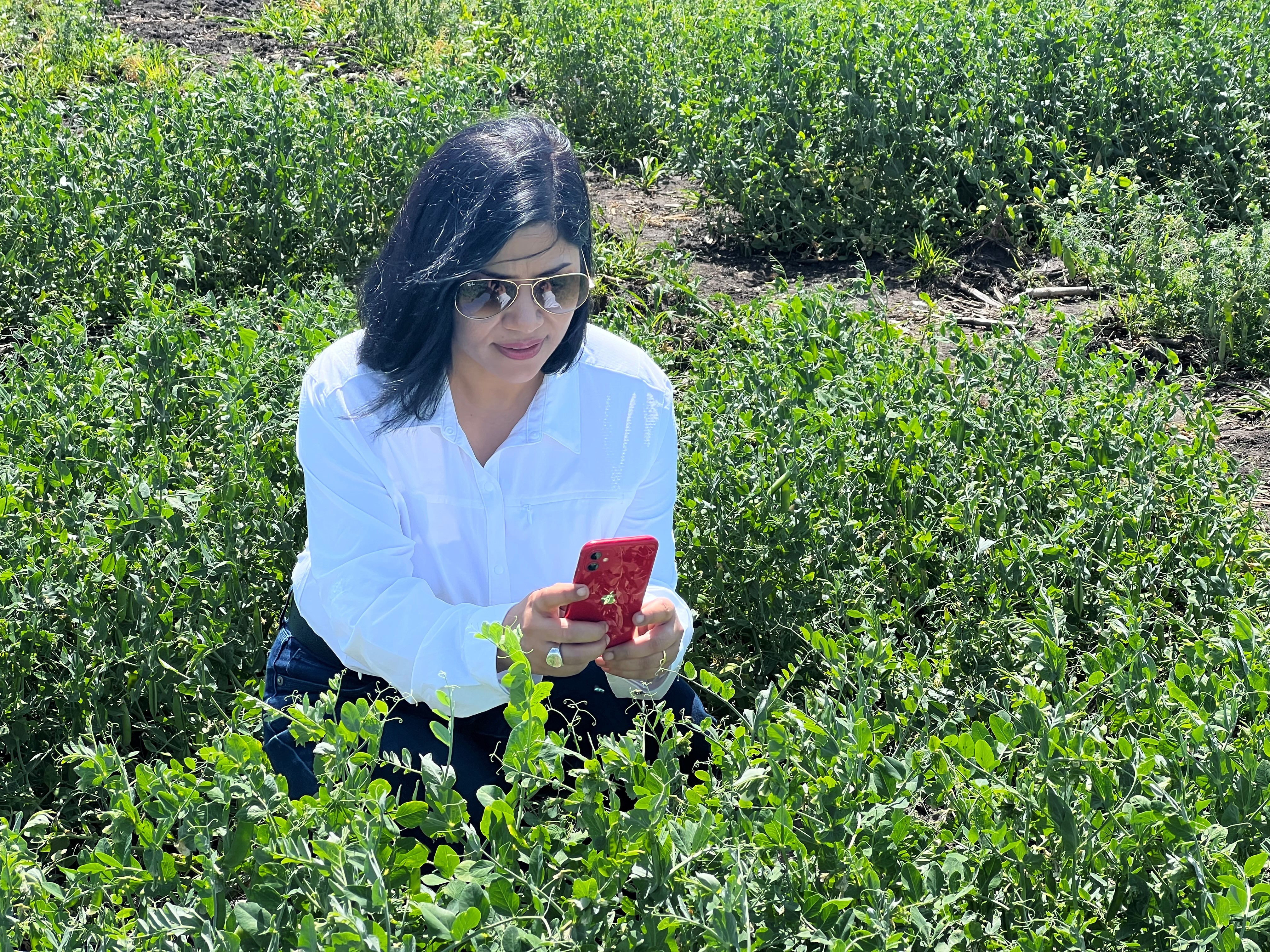 Arti Singh taking pictures in a farm field