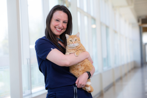 Maia Farber wears veterinary scrubs and holds a cat at the ISU College of Veterinary Medicine