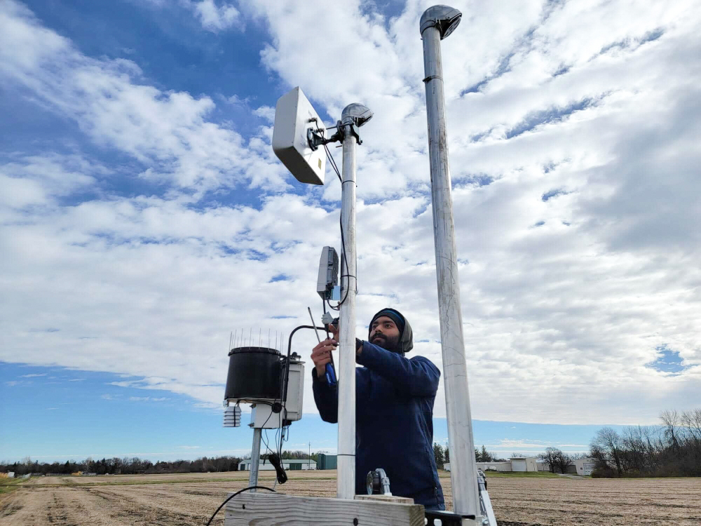 Graduate student Md Nadim helps deploy hardware at an Iowa State research farm for the ARA rural broadband project.
