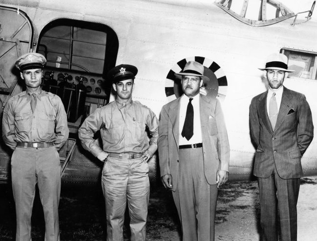 Patterson posing by airplane with military personnel